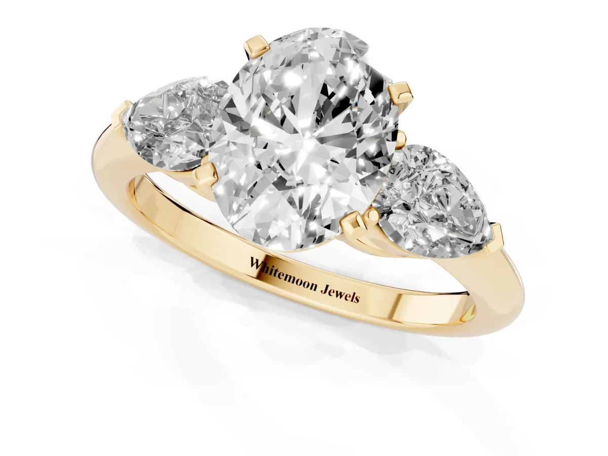 Three-Stone Oval Cut Diamond Ring with Pear Side Stones and Four-Prong Setting Yellow gold