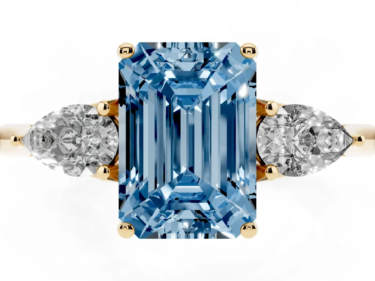 Fancy Blue Three-Stone Emerald Cut Diamond Ring with Pear Side Stones in Four-Prong Setting Yellow gold