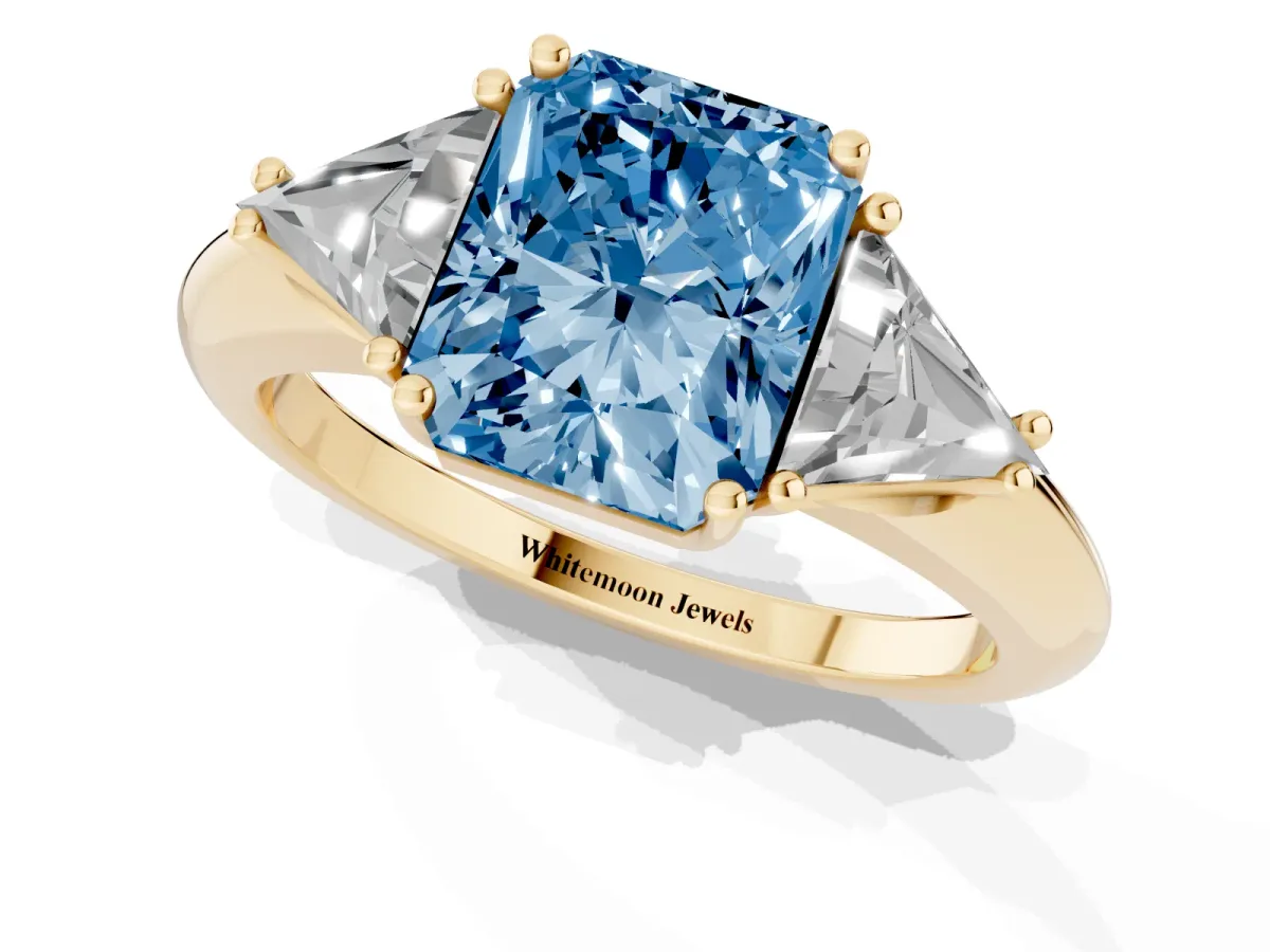 Fancy Blue Three-Stone Radiant Cut Diamond Engagement Ring with Trillion Side Stones and Prong Setting Yellow gold