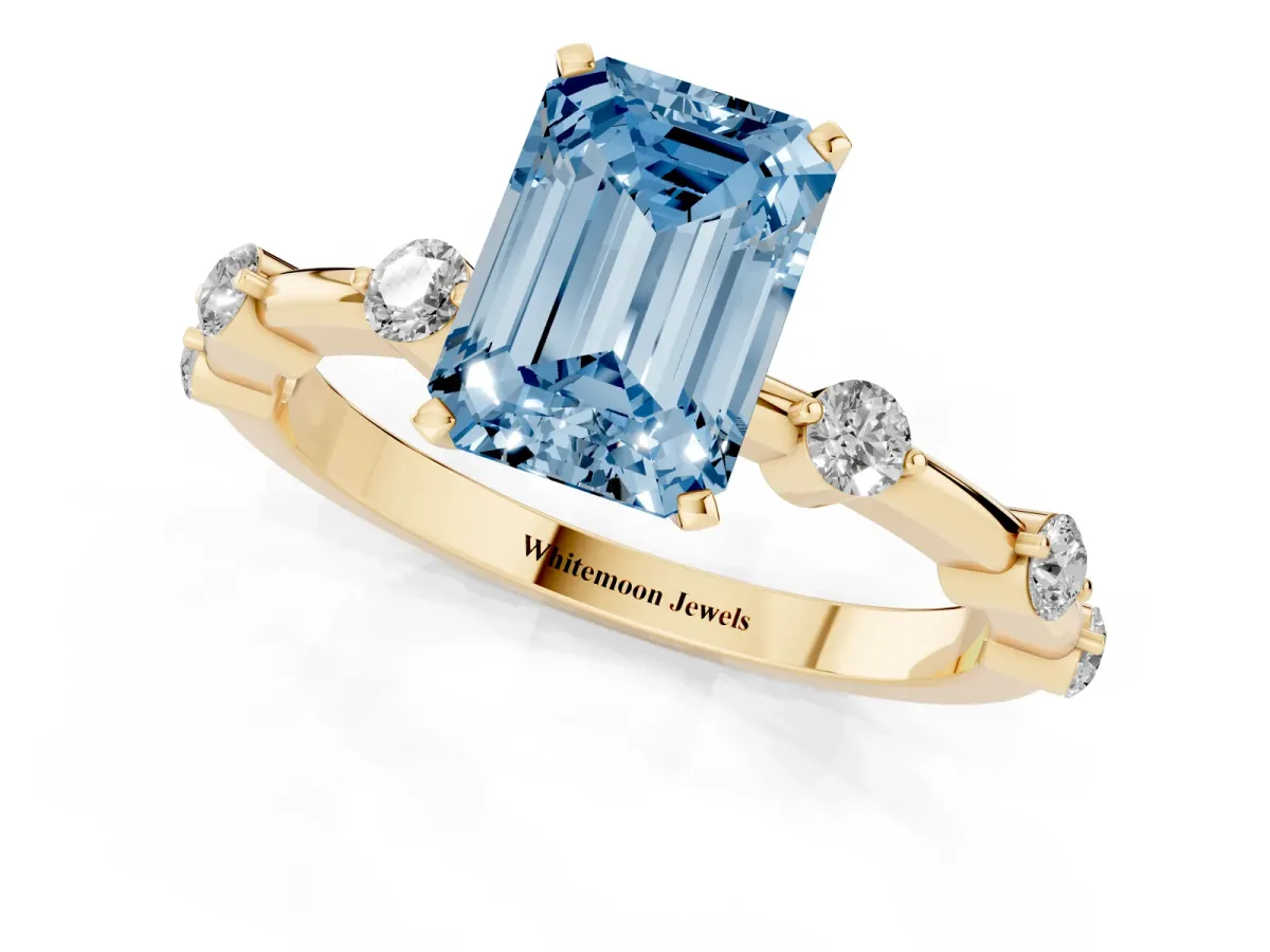 Fancy Blue Emerald Cut Solitaire Diamond Ring with Bezel Set Side Stones and Prong Setting Yellow gold