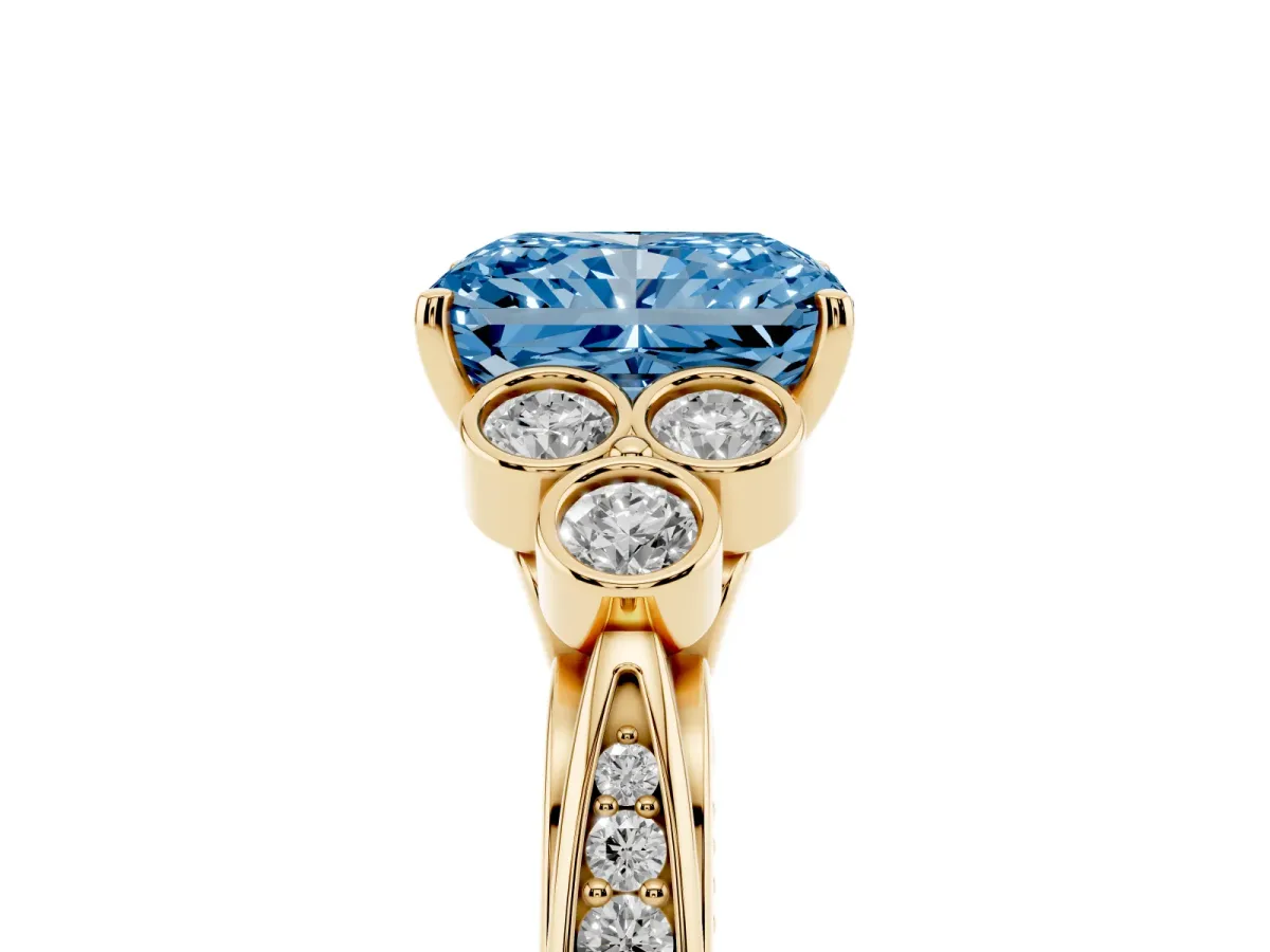 Fancy Blue Radiant Cut Cut Diamond Engagement Ring with Bezel Set Round Side Stones and Prong Setting Yellow gold
