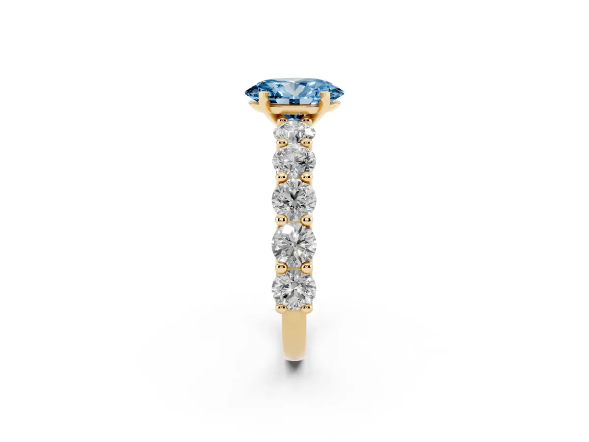 Fancy Blue Oval Cut Diamond Prong Setting with Side Stones on a Pave Band Yellow gold