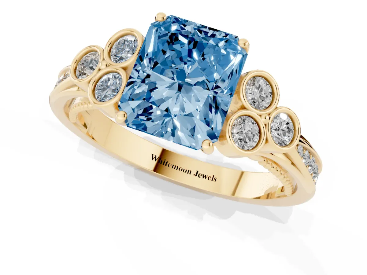 Fancy Blue Radiant Cut Cut Diamond Engagement Ring with Bezel Set Round Side Stones and Prong Setting Yellow gold