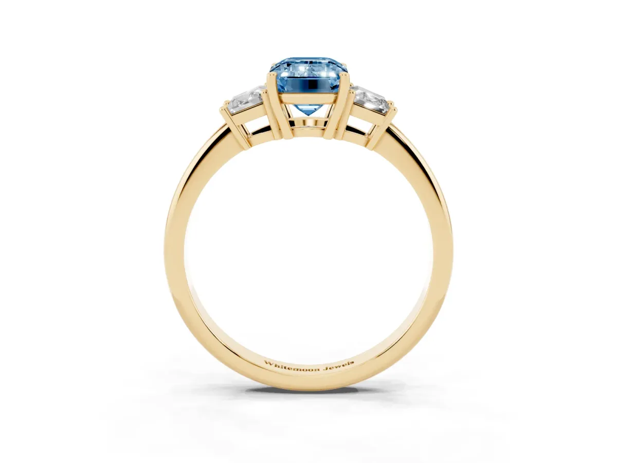 Fancy Blue Emerald Cut Diamond Three-Stone Ring with Trapezoid Side Stones and Prong Setting Yellow gold