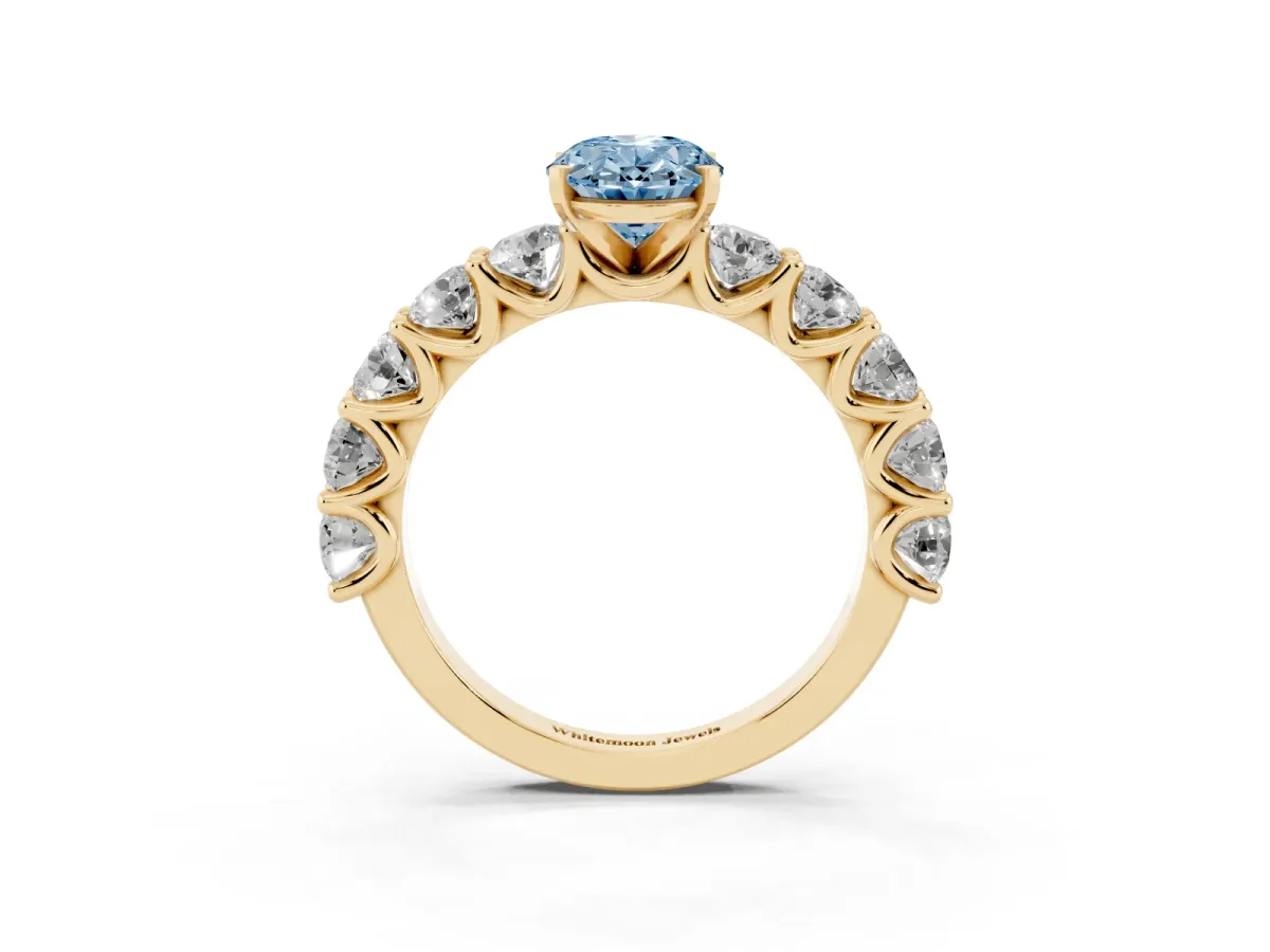 Fancy Blue Oval Cut Diamond Prong Setting with Side Stones on a Pave Band Yellow gold