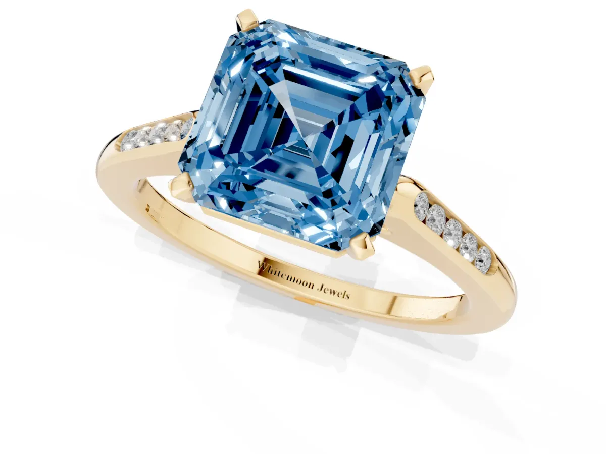 Fancy Blue Asscher Cut Diamond Solitaire Ring with Channel Set Round Band and Prong Setting Yellow gold