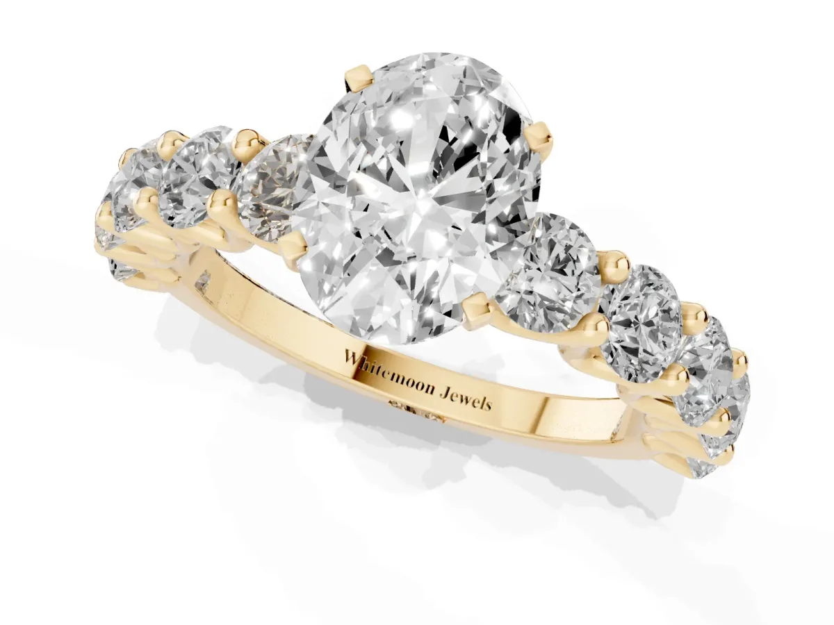 Oval Cut Diamond Prong Setting with Side Stones on a Pave Band Yellow gold