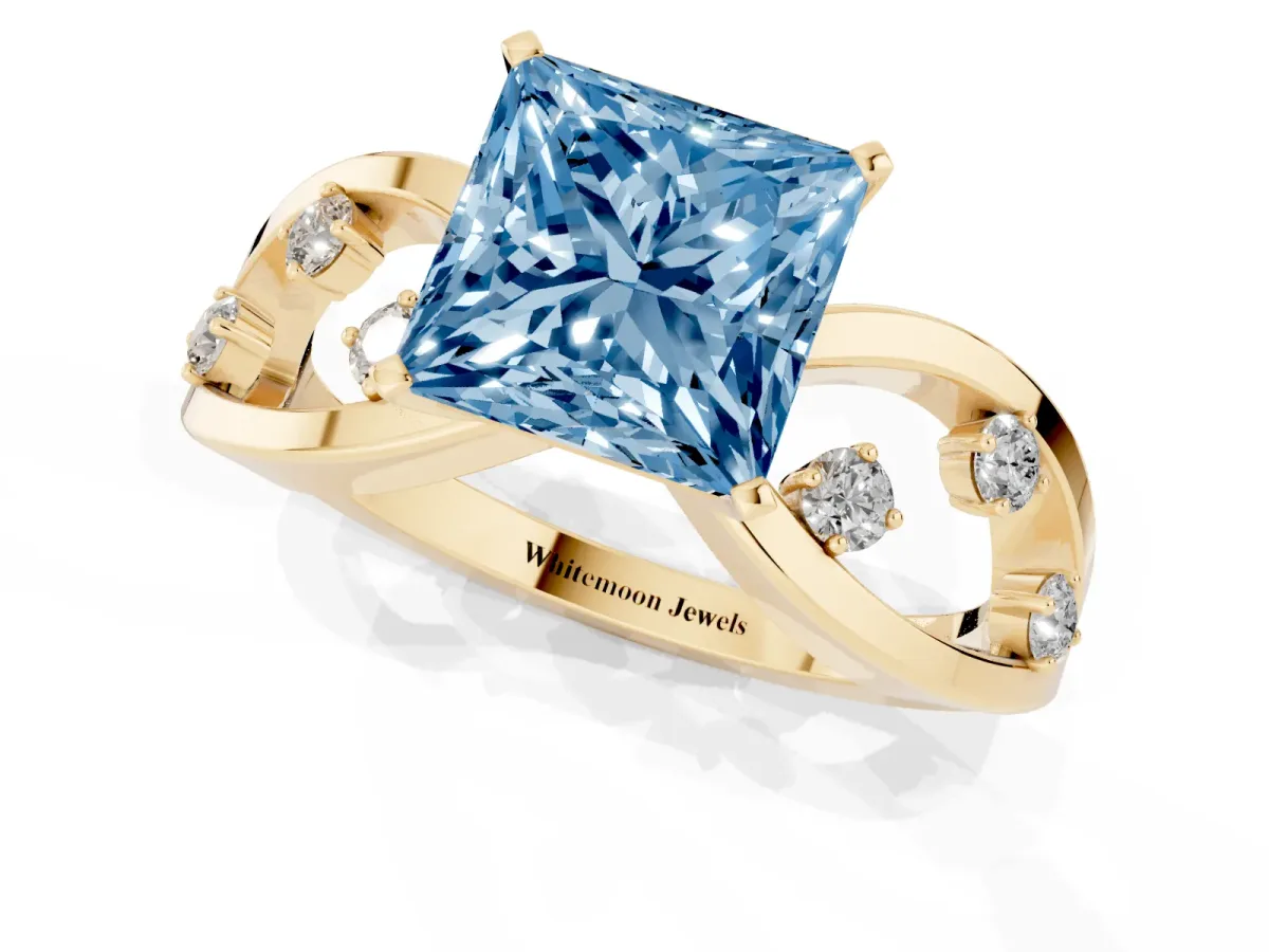 Fancy Blue Princess Cut Cut Solitaire Diamond with Side Stones on Criss-Cross Band and Four-Prong Setting Yellow gold