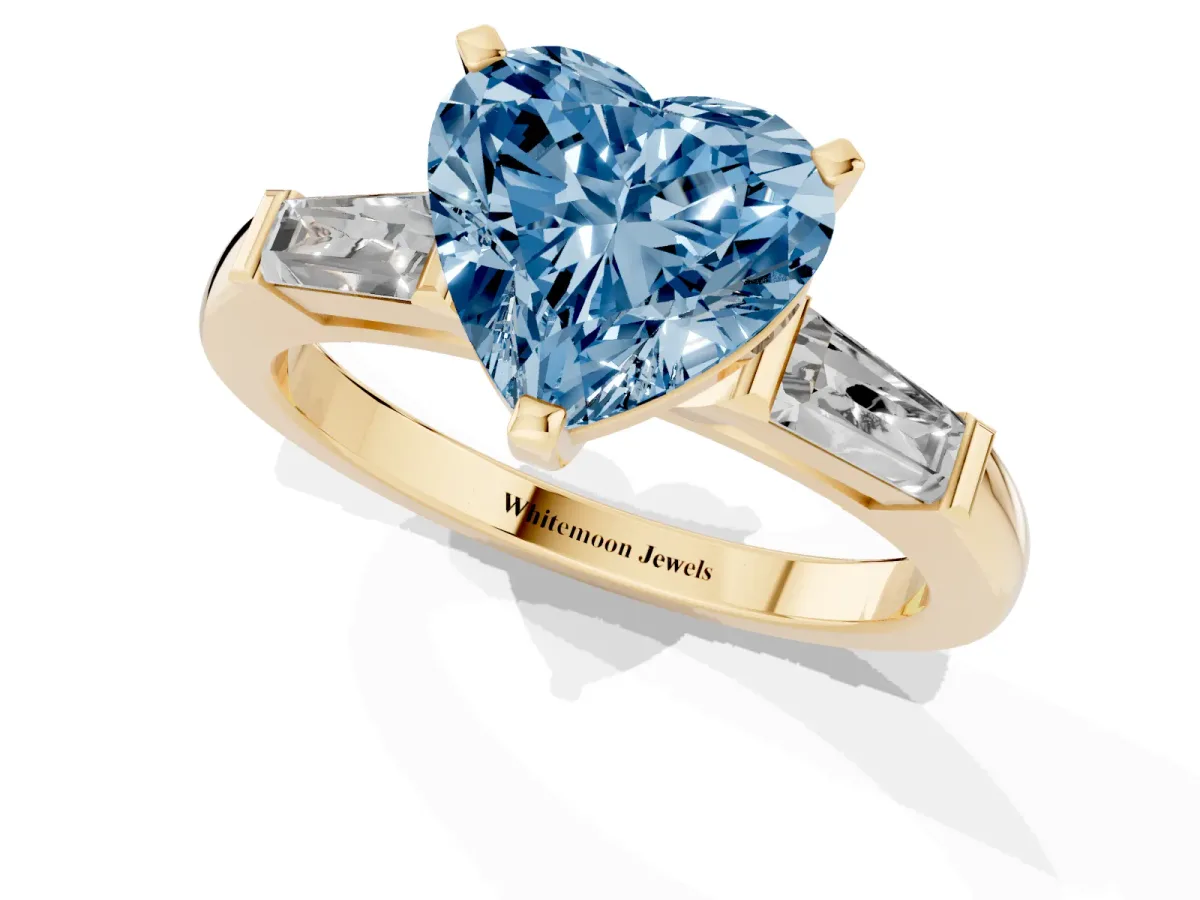 Fancy Blue Heart Cut Solitaire with Tapered Baguette Side Stones on a Classic Band with Four-Prong Setting Yellow gold