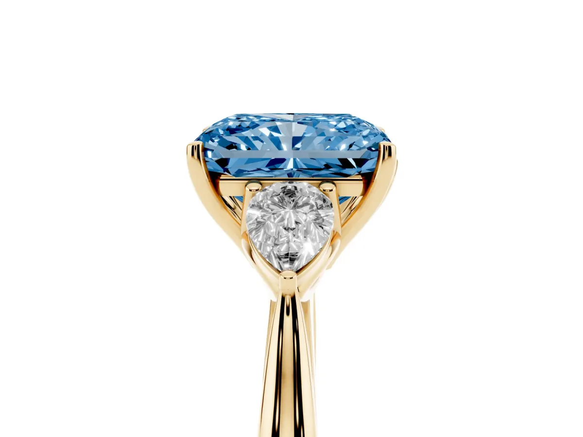 Fancy Blue Three-Stone Radiant Cut Diamond Ring with Pear Side Stones in Four-Prong Setting Yellow gold