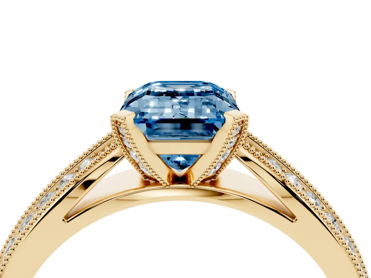 Fancy Blue Emerald Cut Diamond Solitaire Ring with Milgrain Round Pavé Band and Prong Setting Yellow gold
