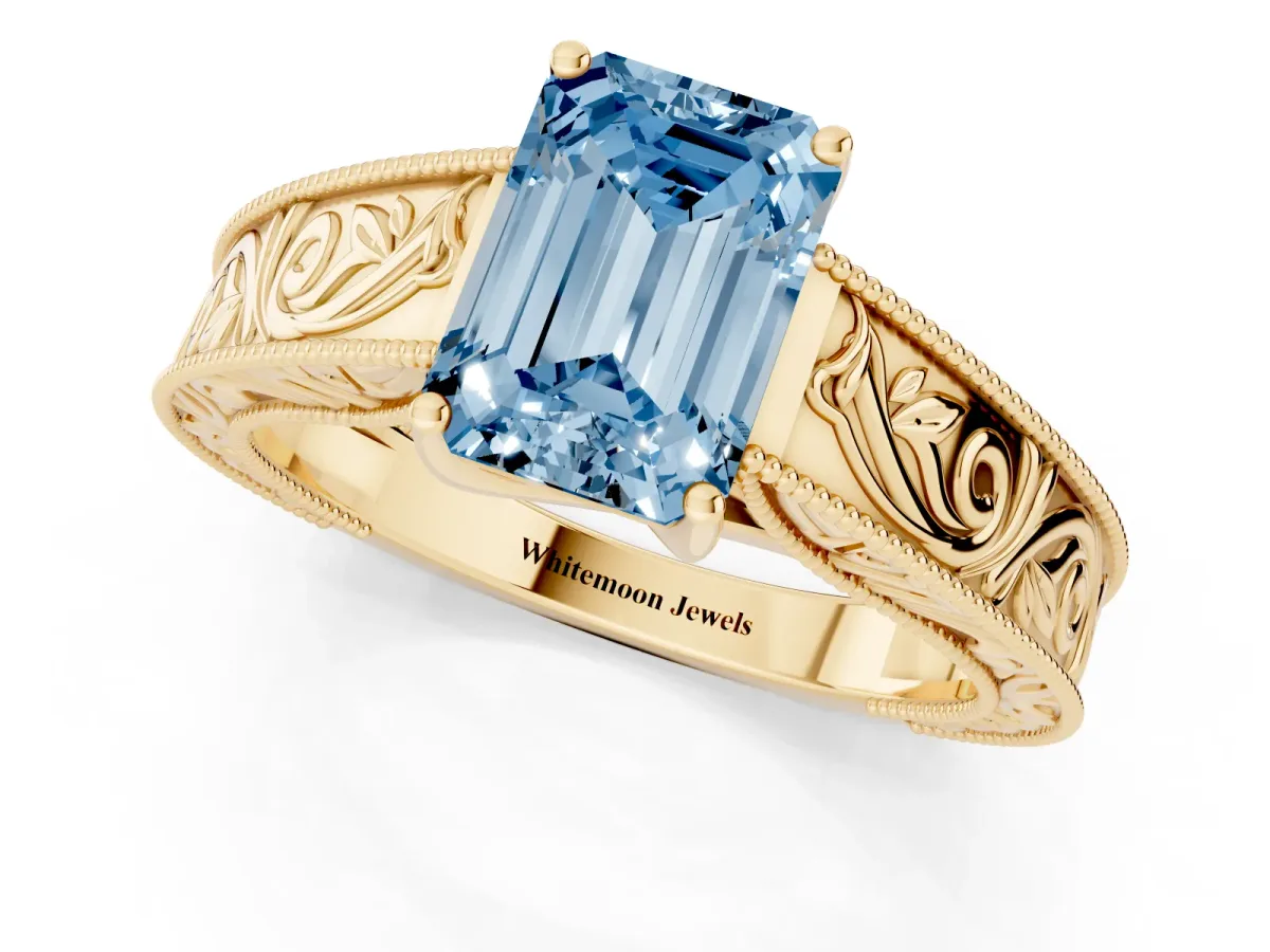 Fancy Blue Emerald Cut Diamond Solitaire Ring with Engraved Band and Four-Prong Setting Yellow gold