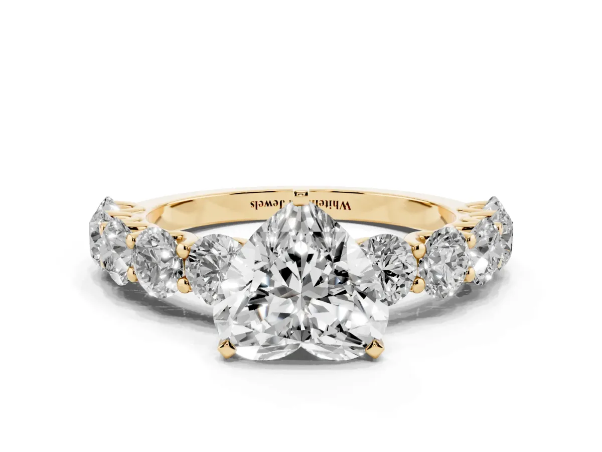Heart Cut Diamond Prong Setting with Side Stones on a Pave Band Yellow gold