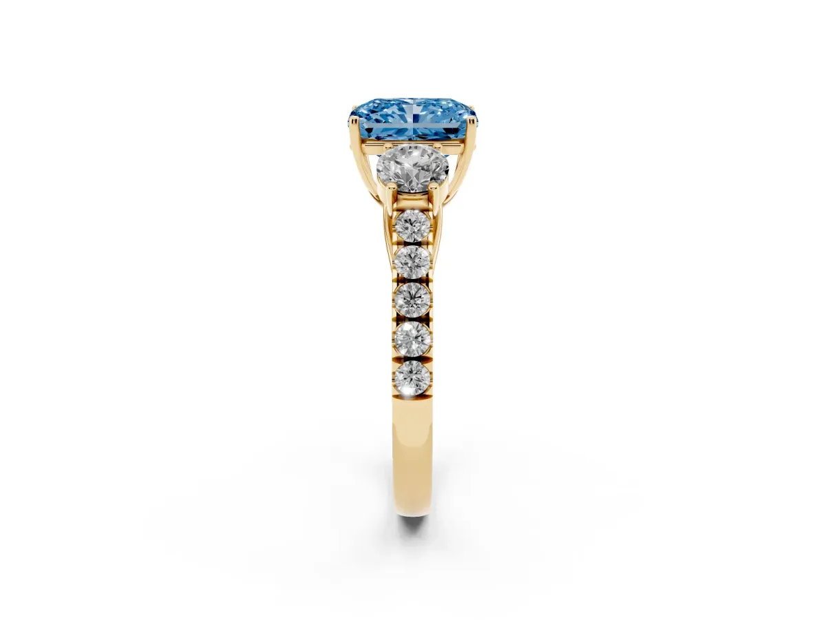 Fancy Blue Radiant Cut Cut Diamond Three-Stone Ring with Round Side Stones and Pavé Band Yellow gold