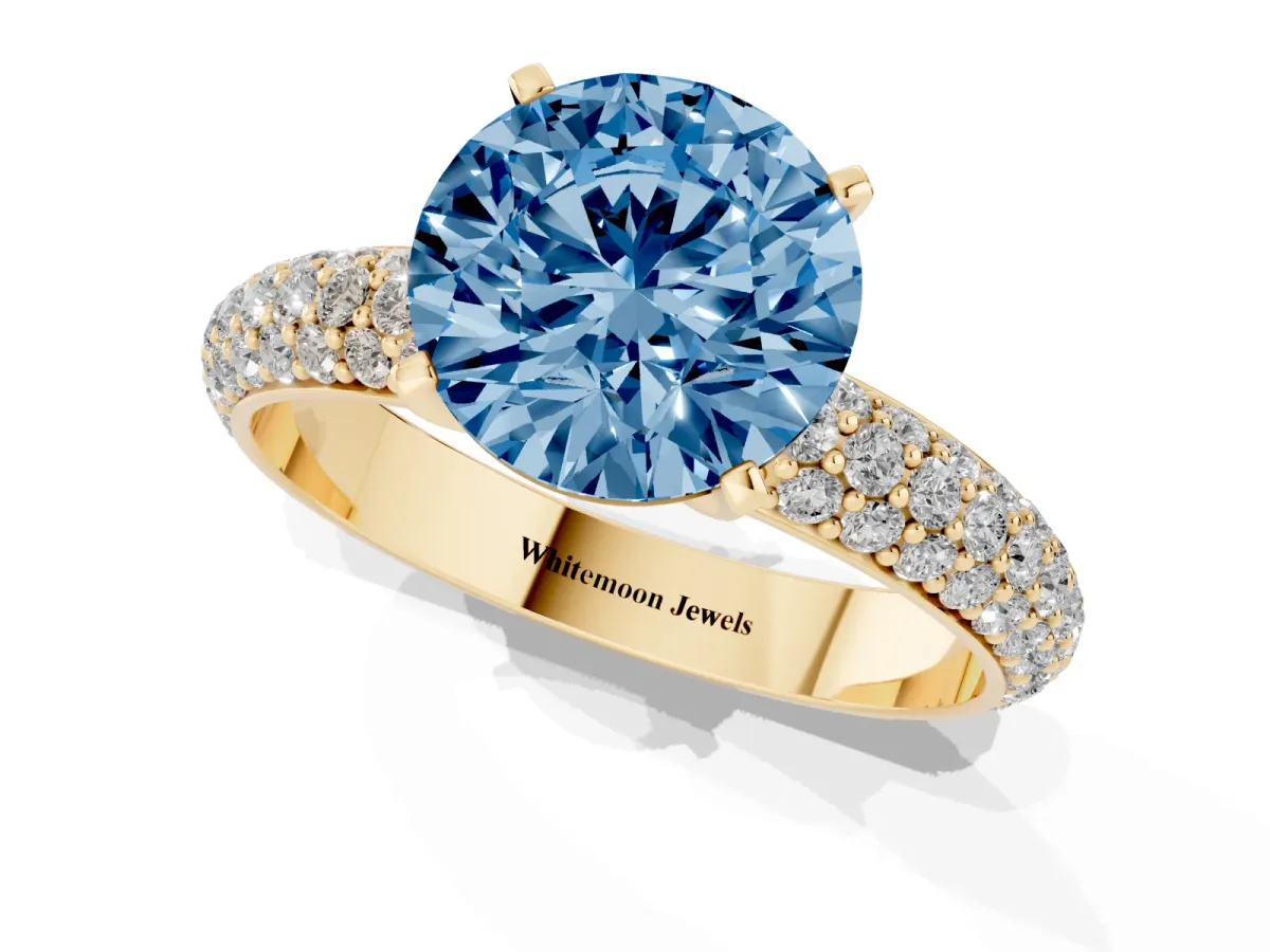 Fancy Blue Round Cut Diamond Solitaire Ring with Prong Setting and Pavé Band Yellow gold