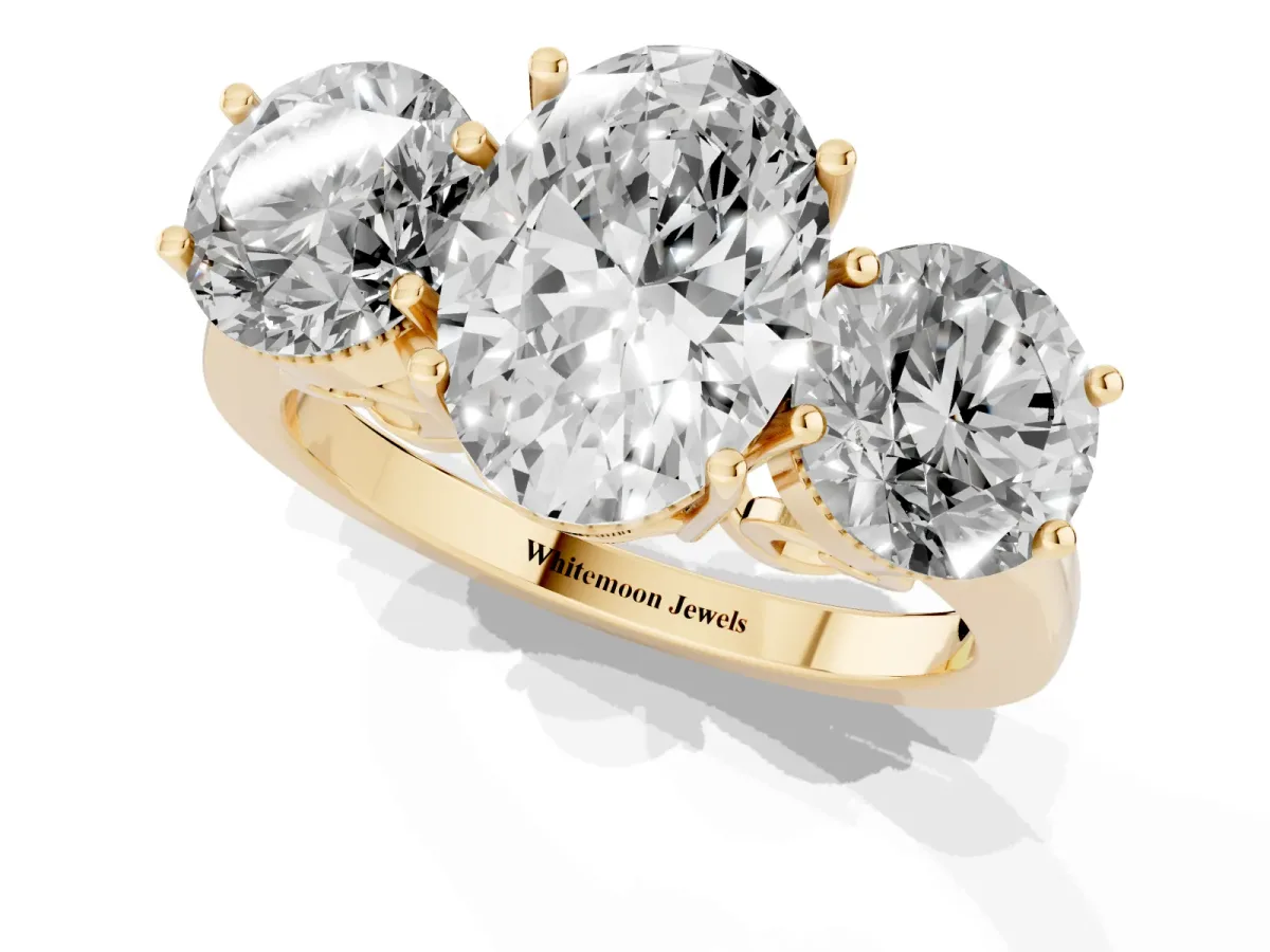 Three-Stone Oval Cut Diamond Engagement Ring with Prong Setting on a Classic Band Yellow gold