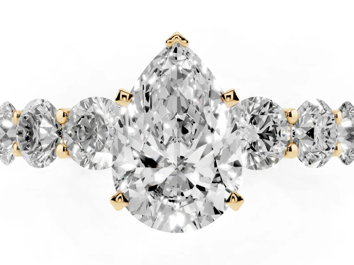 Pear Cut Diamond Prong Setting with Side Stones on a Pave Band Yellow gold