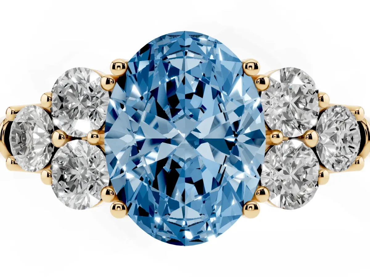 Fancy Blue Oval Cut Cut Diamond Cluster Ring with Round Accent Stones and Prong Setting on a Classic Band Yellow gold