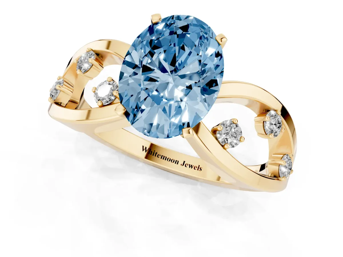 Fancy Blue Oval Cut Cut Solitaire Diamond with Side Stones on Criss-Cross Band and Four-Prong Setting Yellow gold