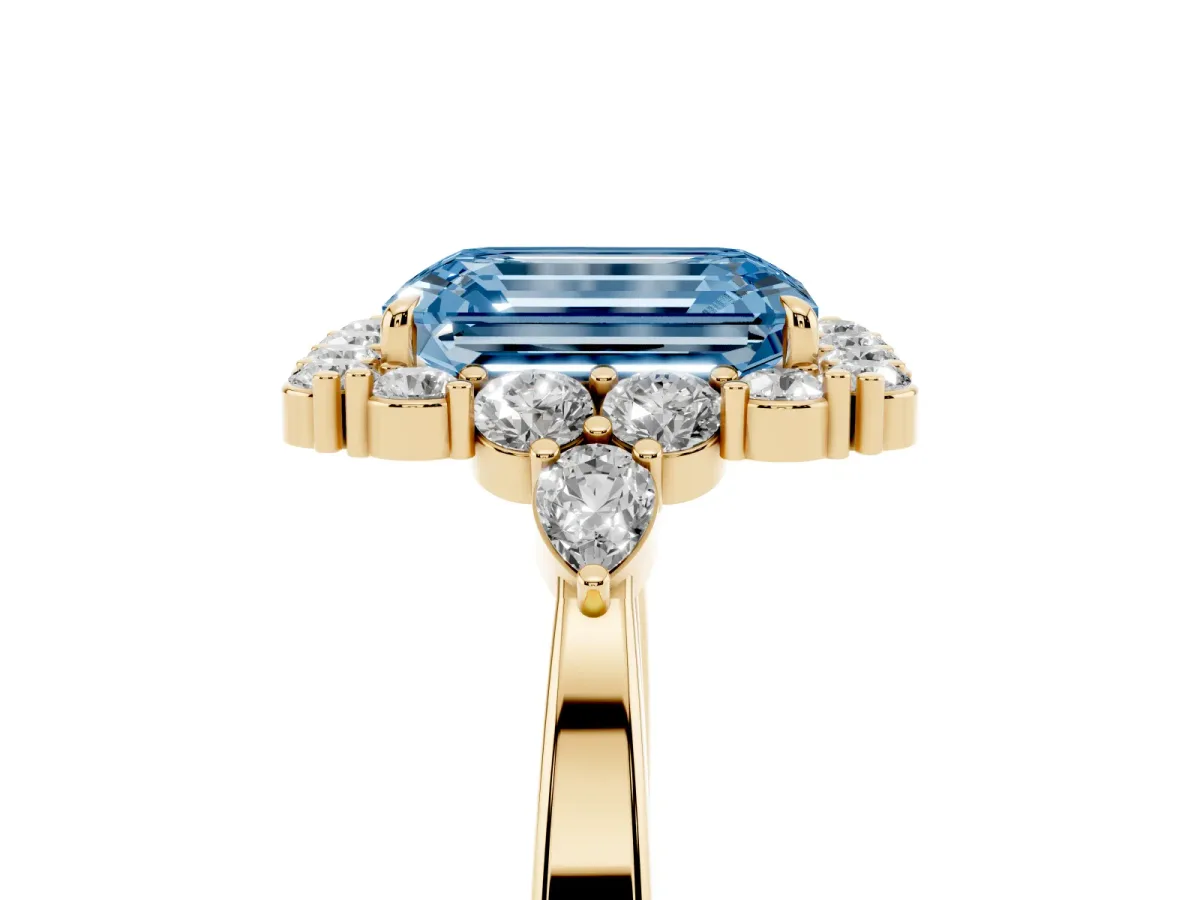 Fancy Blue Emerald Cut Diamond Halo Ring with Pear Side Stones and Prong Setting Yellow gold