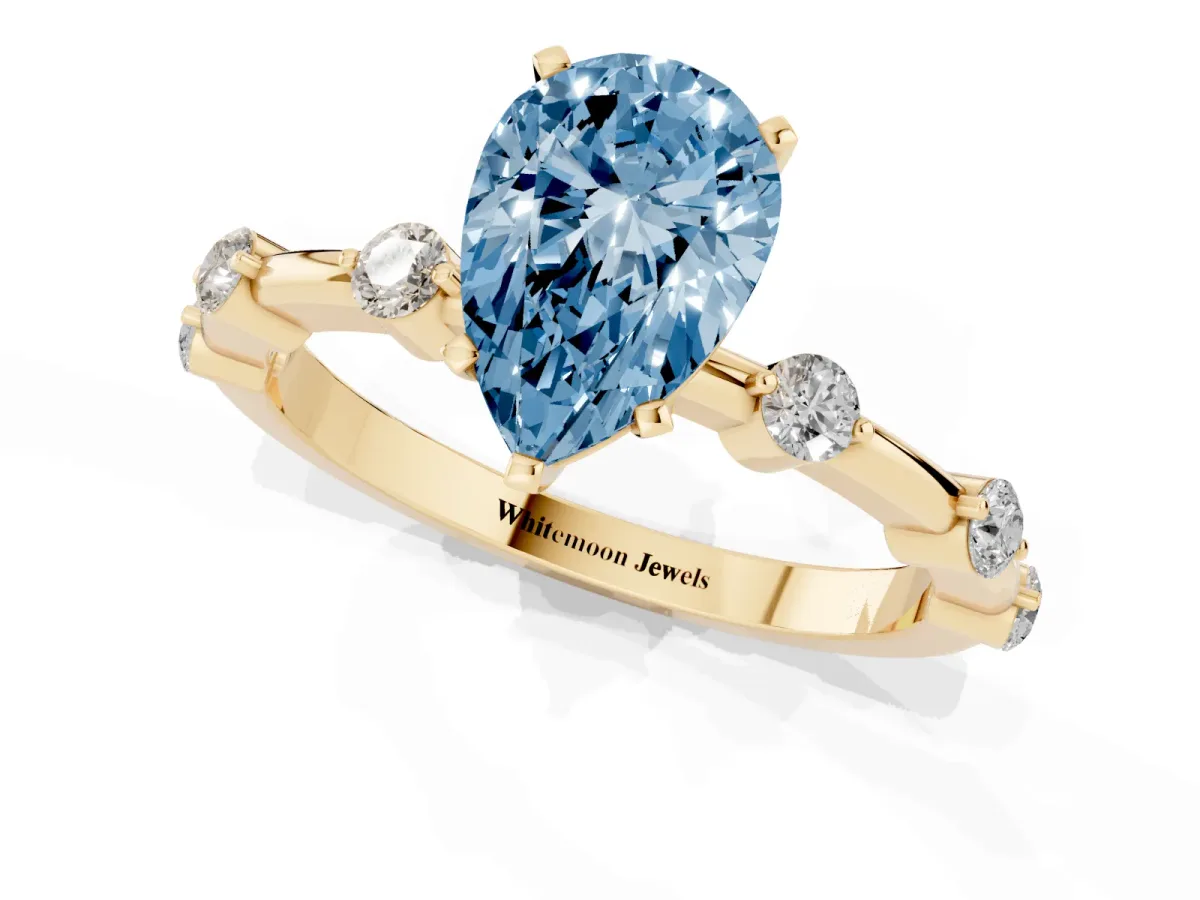 Fancy Blue Pear Cut Solitaire Diamond Ring with Bezel Set Side Stones and Prong Setting Yellow gold