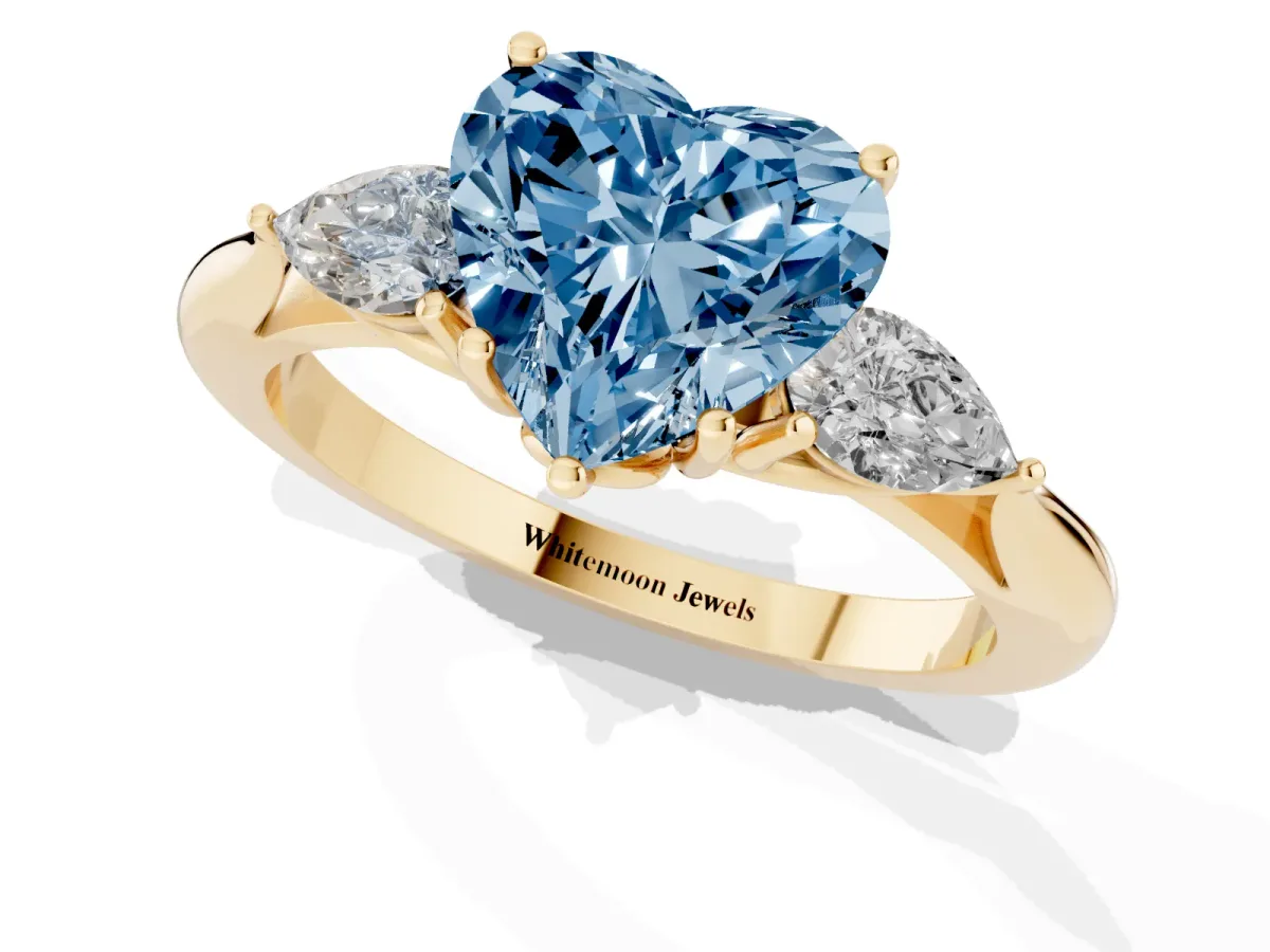 Fancy Blue Three-Stone Heart Cut Diamond Ring with Pear Side Stones in Four-Prong Setting Yellow gold