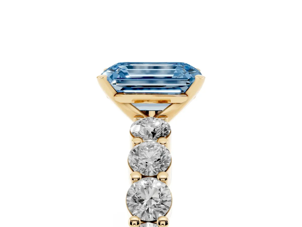Fancy Blue Emerald Cut Diamond Solitaire Ring with Shared Prong Round Side Stones Yellow gold