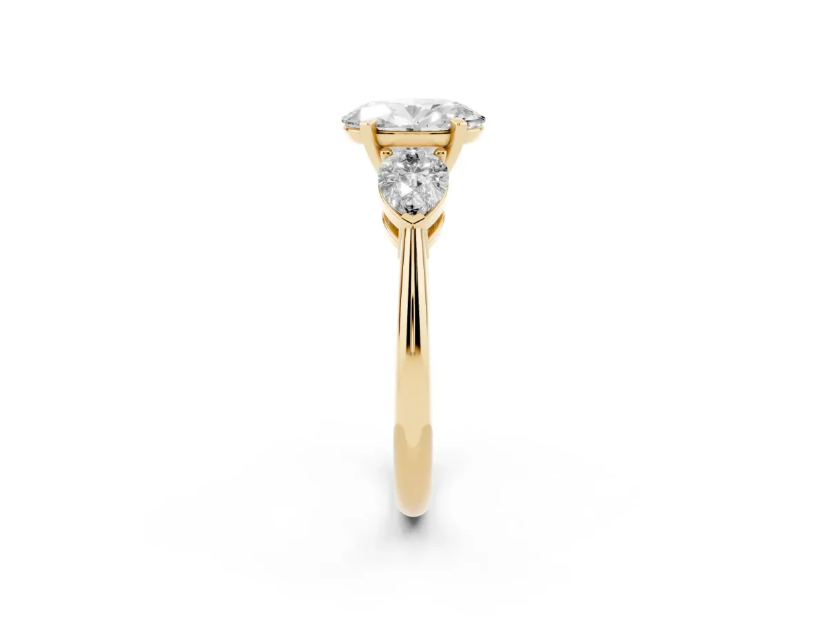 Three-Stone Oval Cut Diamond Ring with Pear Side Stones and Four-Prong Setting Yellow gold