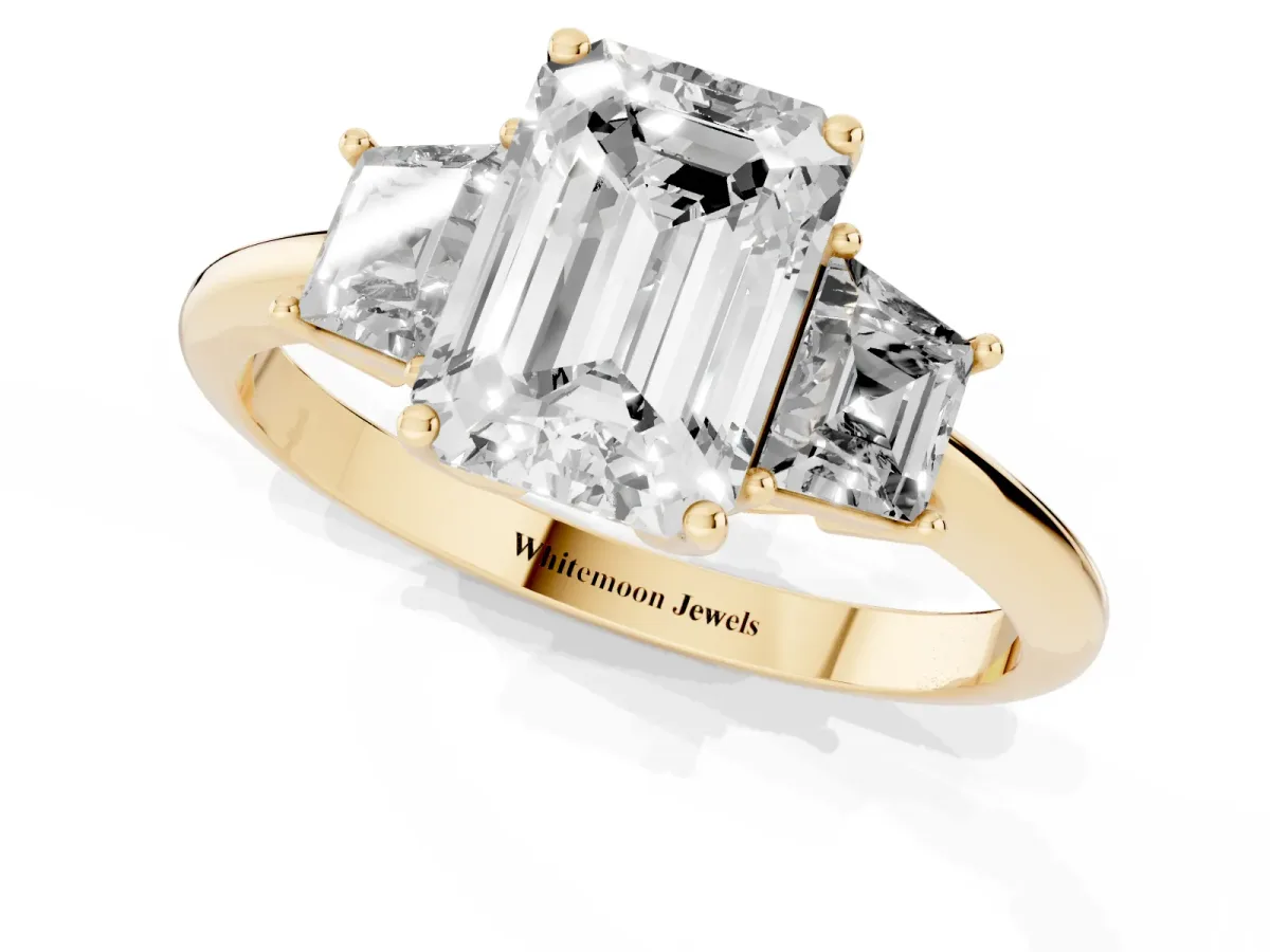 Emerald Cut Diamond Three-Stone Ring with Trapezoid Side Stones and Prong Setting Yellow gold