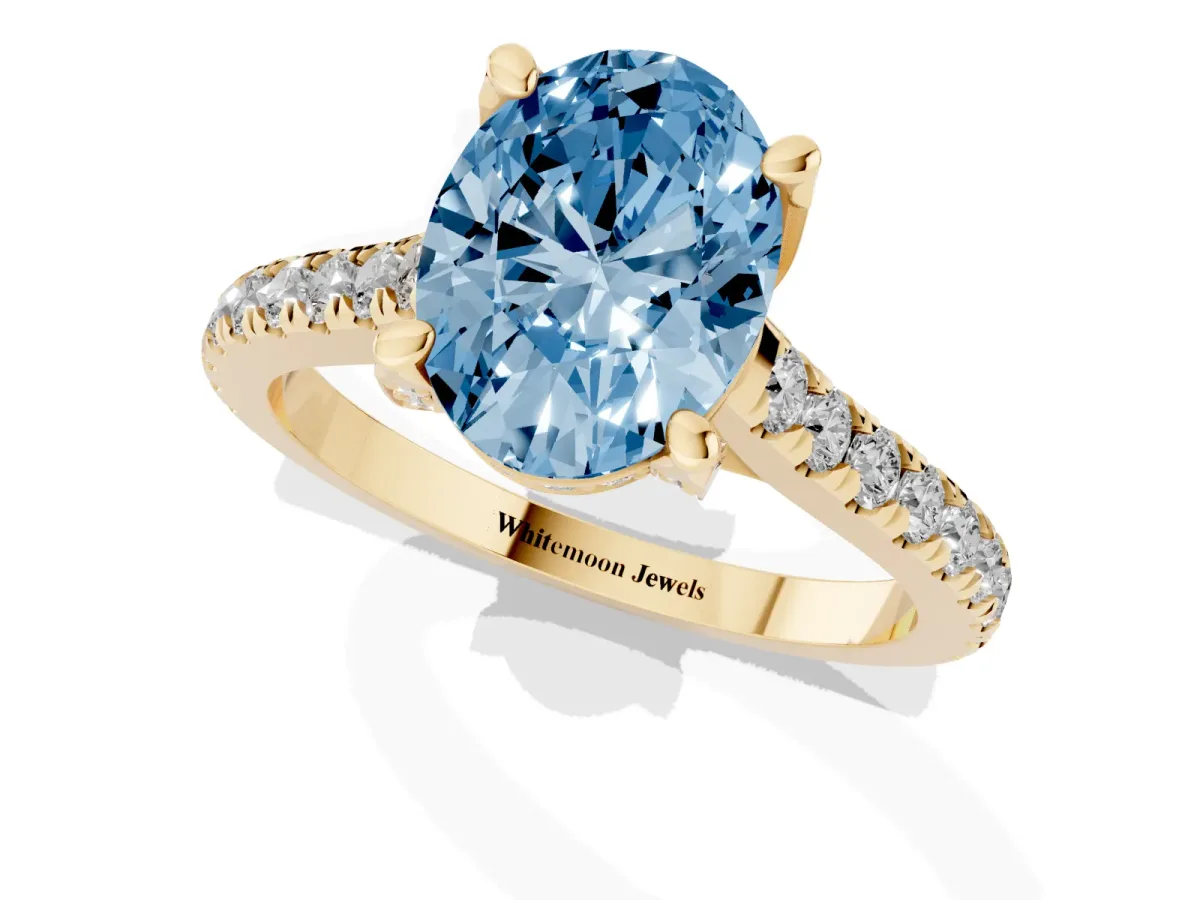 Fancy Blue Oval Cut Brilliant Diamond Solitaire with Pavé Band and Four-Prong Setting Yellow gold