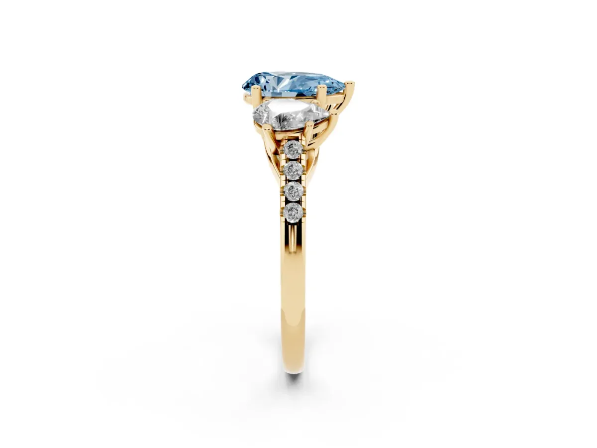 Fancy Blue Three-Stone Pear Cut Diamond Ring with Round Pavé Band and Prong Setting Yellow gold