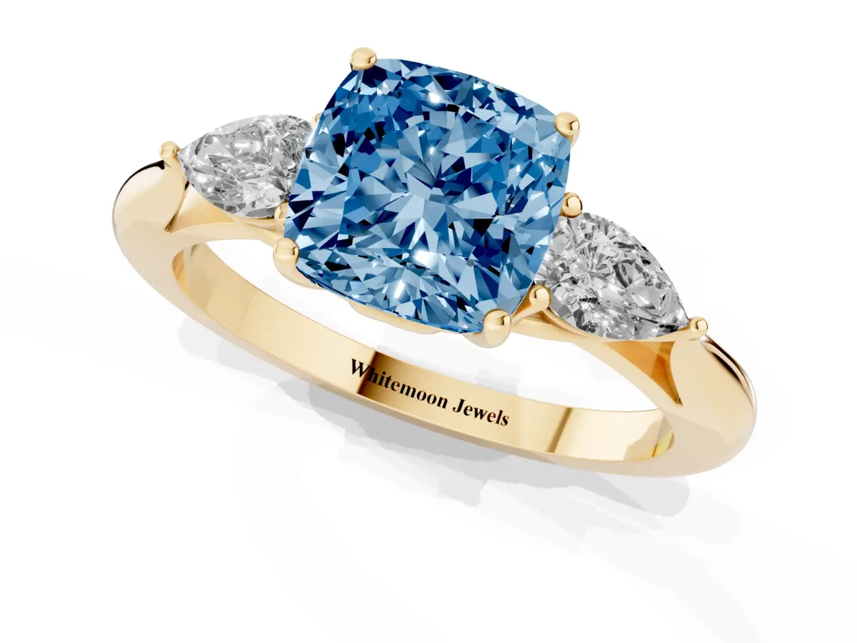 Fancy Blue Cushion Cut Diamond Three-Stone Ring with Pear Side Stones and Prong Setting Yellow gold