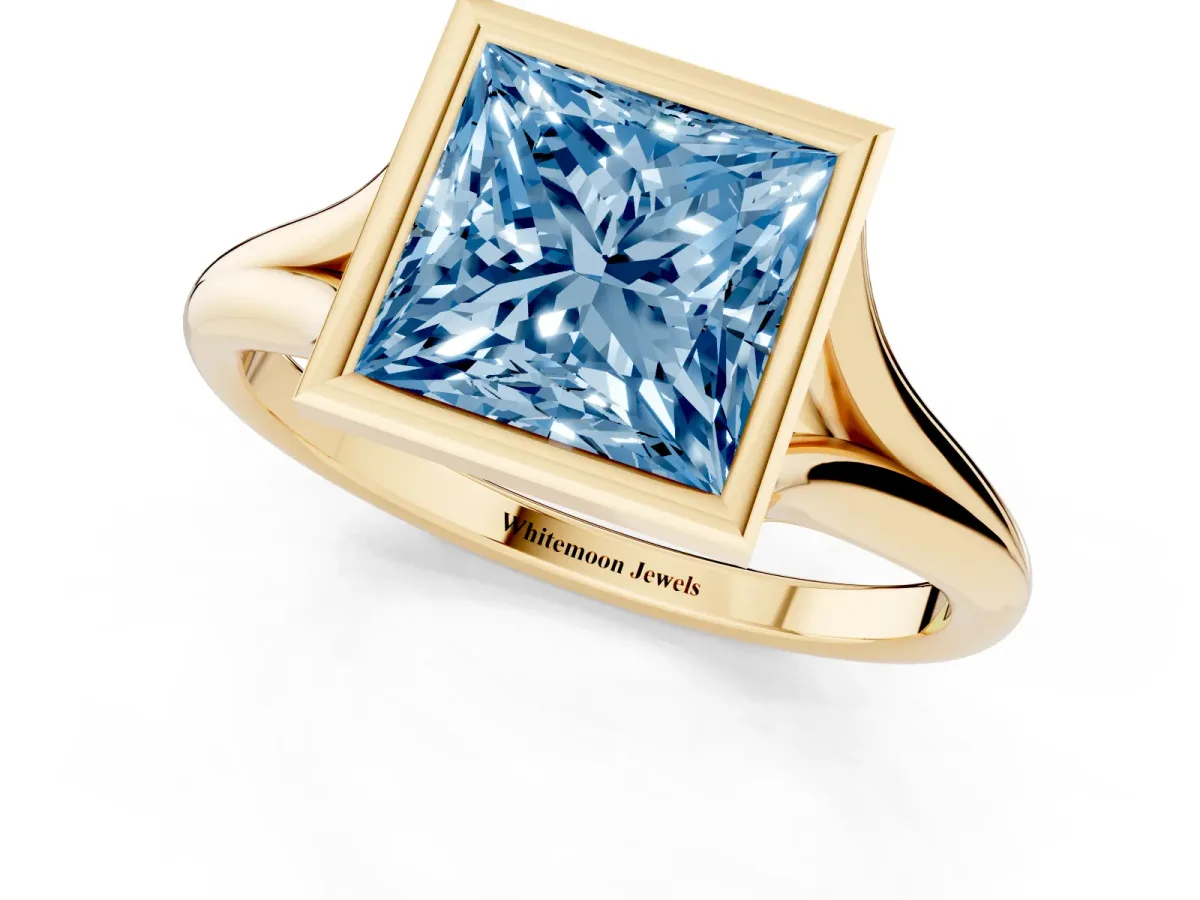 Fancy Blue Bezel Set Princess Cut Cut Solitaire Ring with Tapered Band Yellow gold