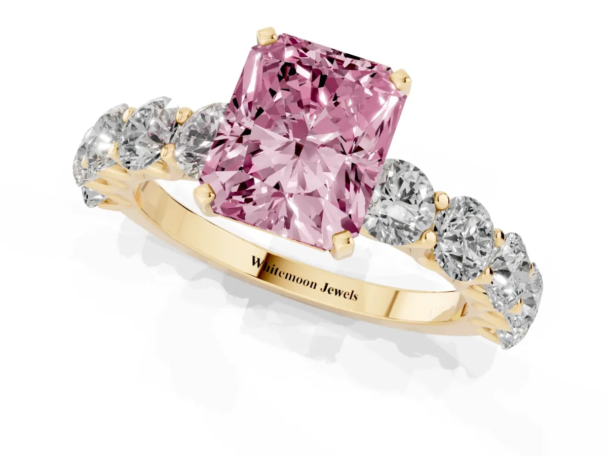 Fancy Pink Radiant Cut Diamond Prong Setting with Side Stones on a Pave Band Yellow gold