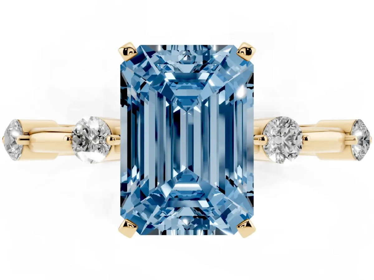 Fancy Blue Emerald Cut Solitaire Diamond Ring with Bezel Set Side Stones and Prong Setting Yellow gold