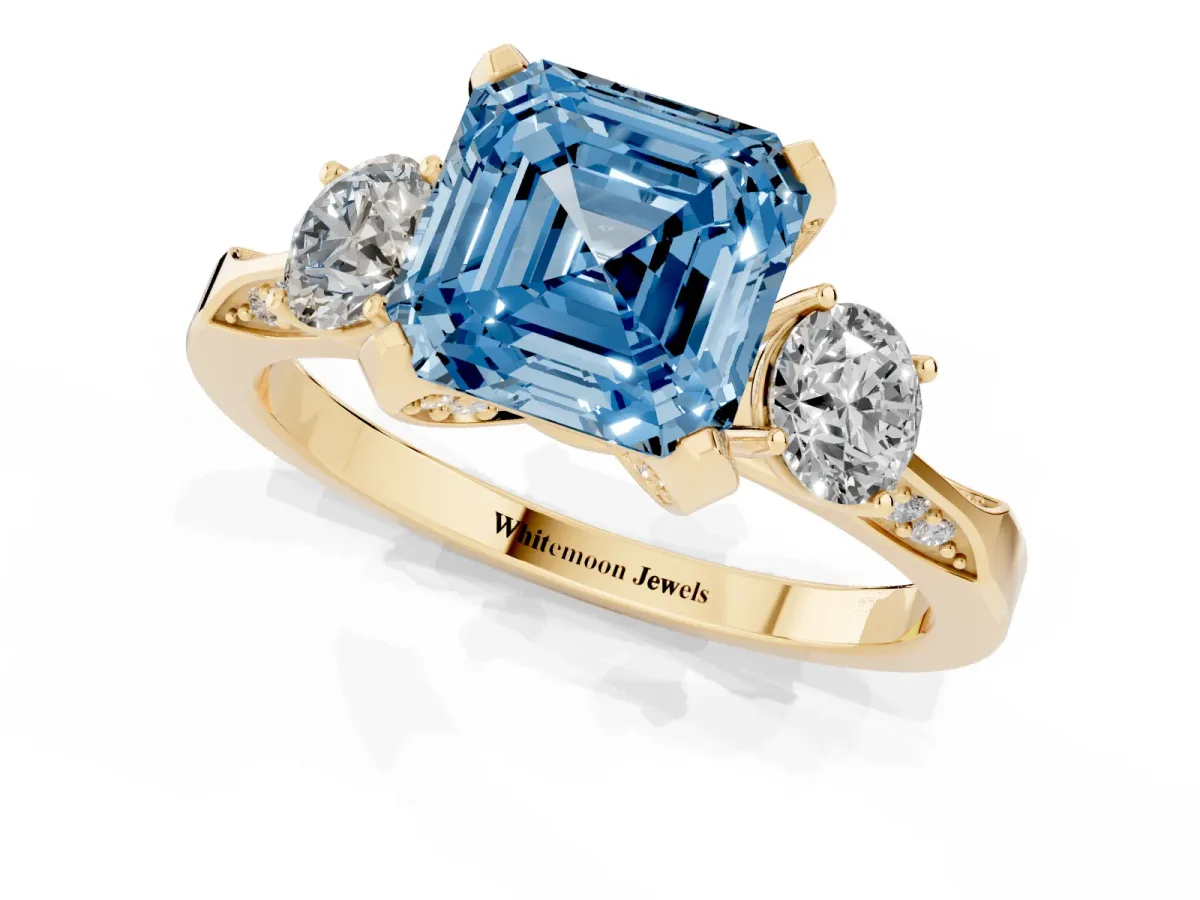 Fancy Blue Asscher Cut Brilliant Three-Stone Diamond Ring with Pavé Band and Four-Prong Setting Yellow gold