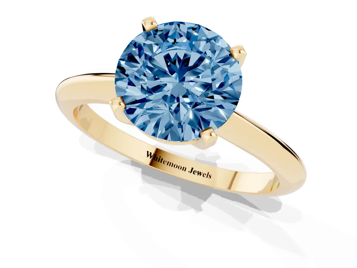 Fancy Blue Round Cut Cut Solitaire Ring with Four-Prong Setting on a Classic Band Yellow gold