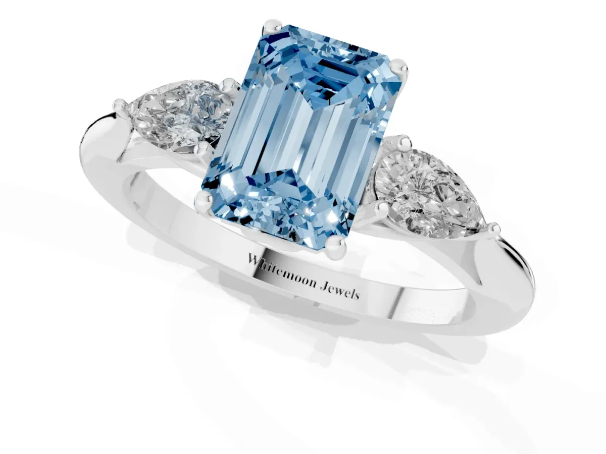 Fancy Blue Three-Stone Emerald Cut Brilliant Diamond Solitaire Ring with Tapered Band and Four-Prong Setting White gold
