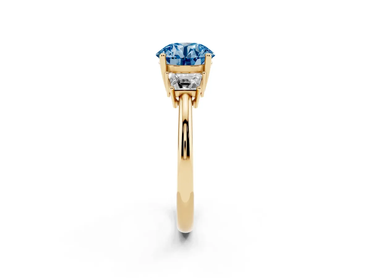 Fancy Blue Round Cut Diamond Three-Stone Ring with Trapezoid Side Stones and Prong Setting Yellow gold