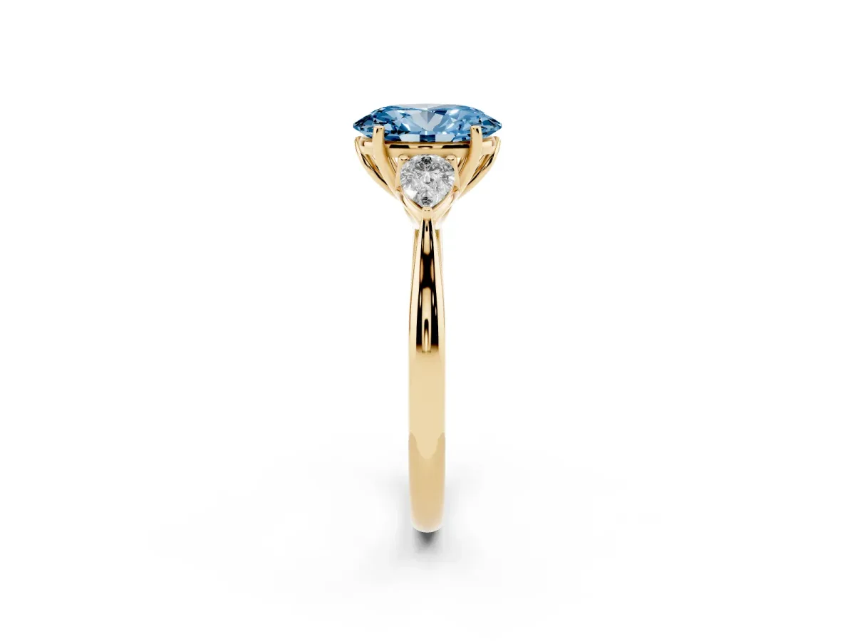 Fancy Blue Three-Stone Oval Cut Diamond Ring with Pear Side Stones in Four-Prong Setting Yellow gold