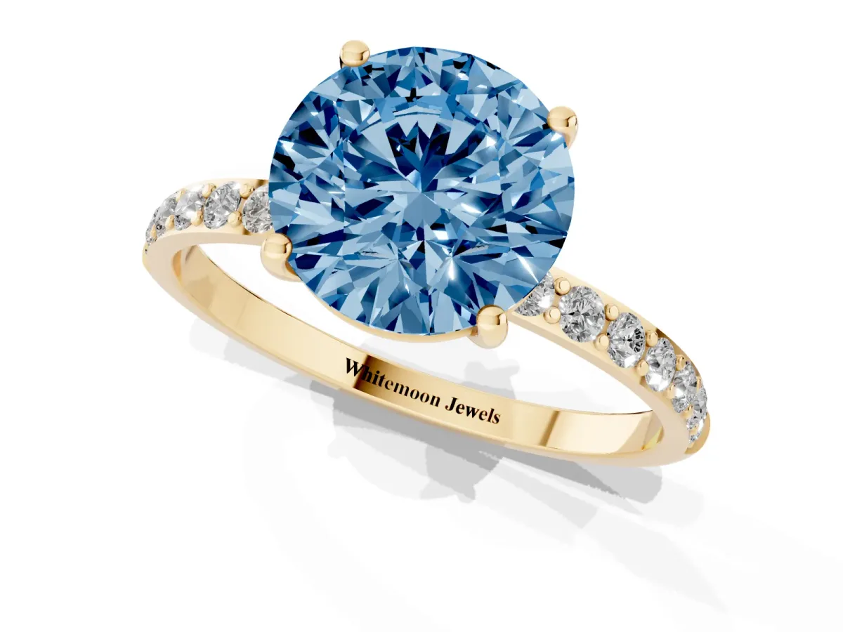 Fancy Blue Round Cut Diamond Solitaire Ring with Round Pavé Shoulders and Prong Setting Yellow gold