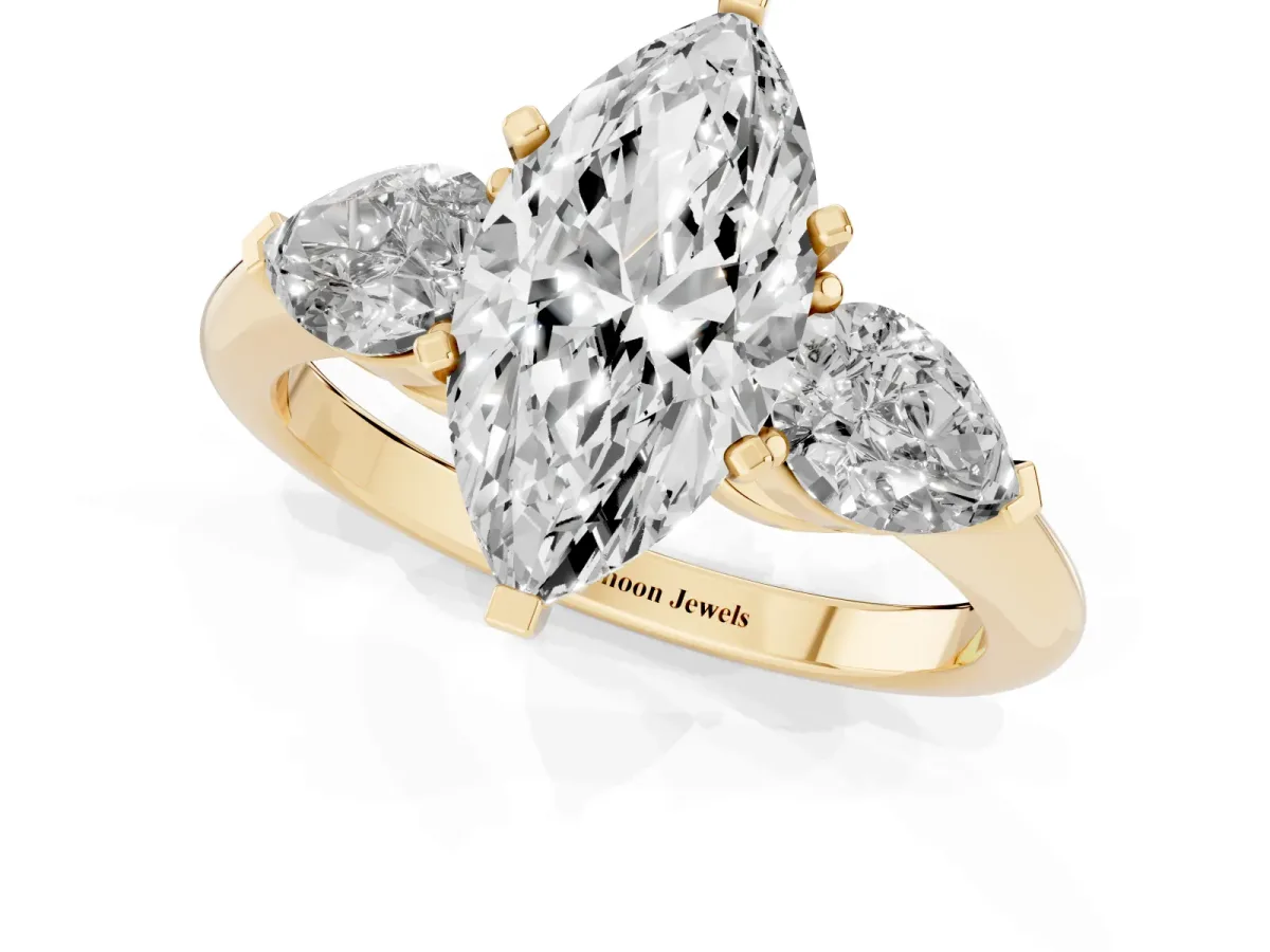 Three-Stone Marquise Cut Diamond Ring with Pear Side Stones and Four-Prong Setting Yellow gold