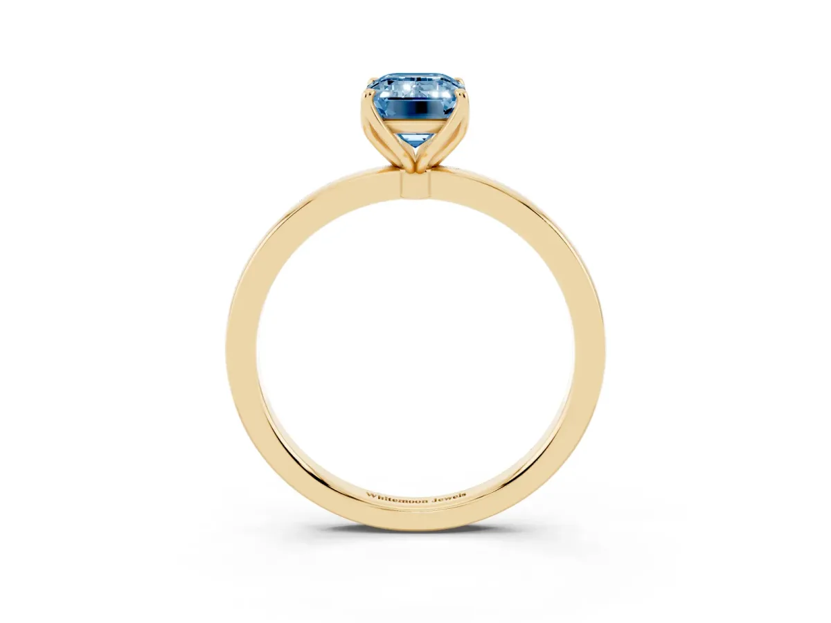 Fancy Blue Emerald Cut Diamond Solitaire Ring with Thin Band and Prong Setting Yellow gold