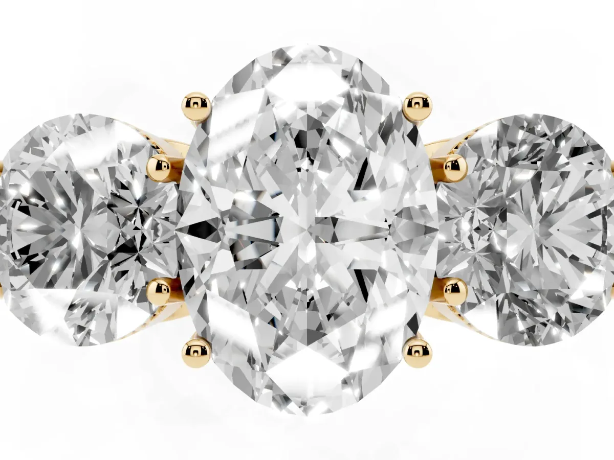 Three-Stone Oval Cut Diamond Engagement Ring with Prong Setting on a Classic Band Yellow gold