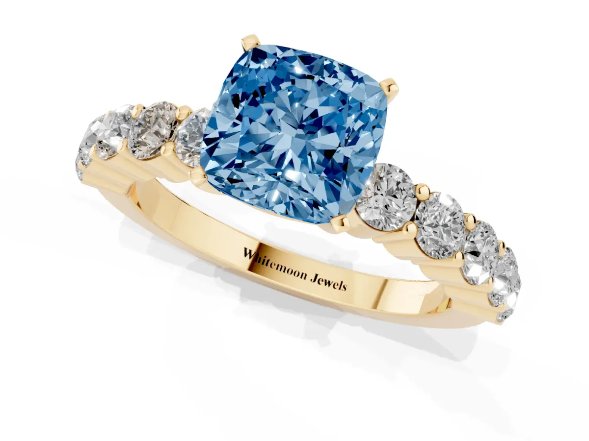 Fancy Blue Cushion Cut Diamond Solitaire Ring with Shared Prong Round Side Stones Yellow gold