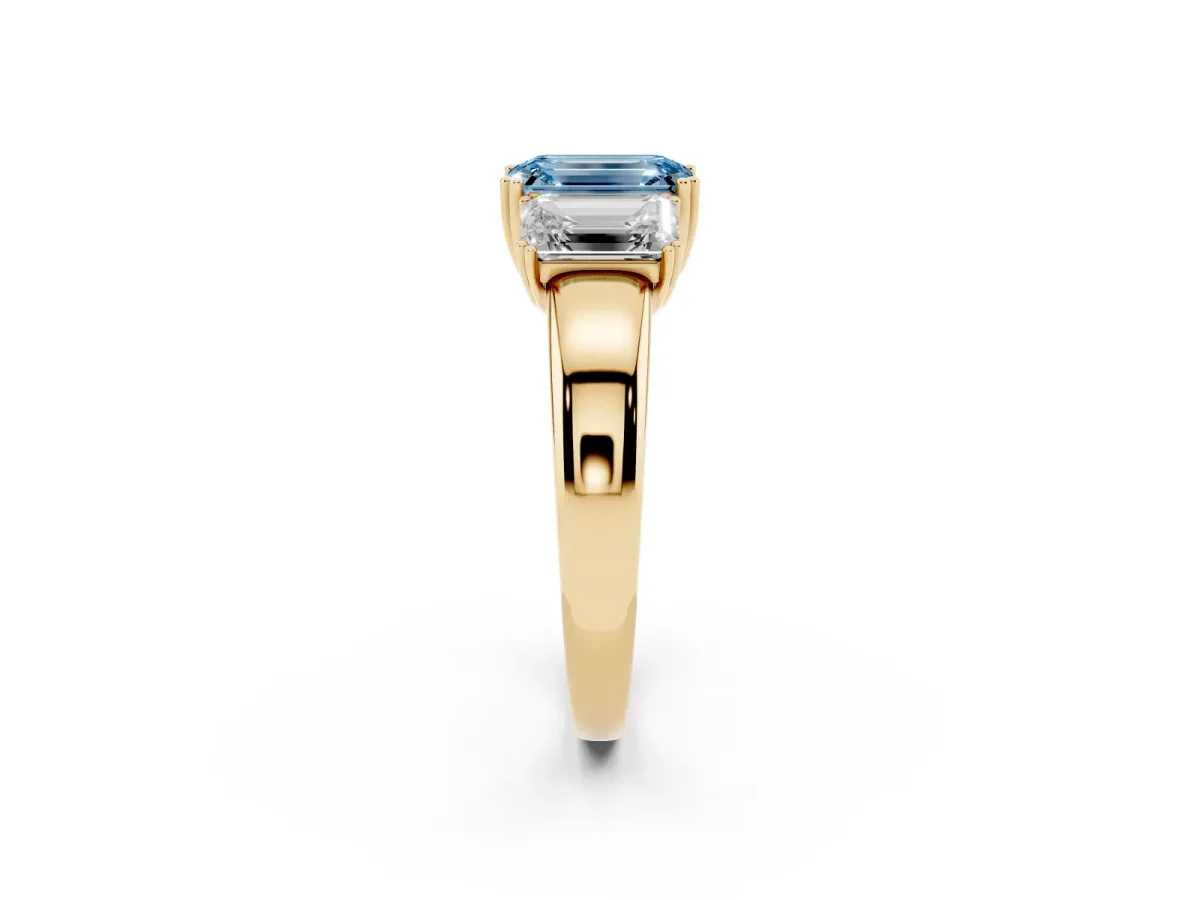 Fancy Blue Three-Stone Emerald Cut Cut Diamond Ring with Channel Set Band and Four-Prong Setting Yellow gold