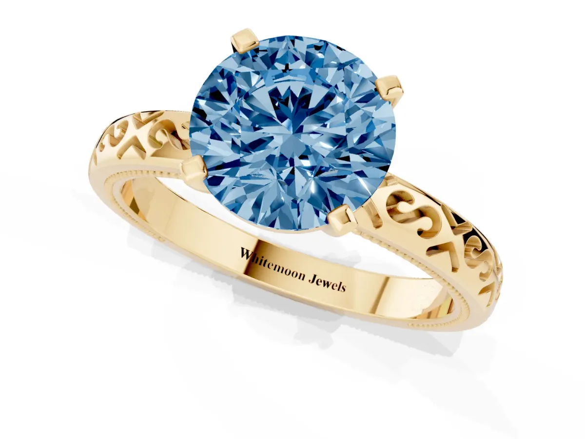 Fancy Blue Round Cut Solitaire Engagement Ring with Scrollwork Band and Four-Prong Setting Yellow gold