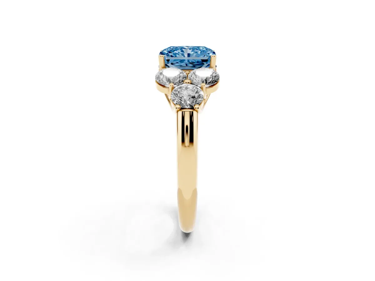 Fancy Blue Radiant Cut Cut Diamond Cluster Ring with Round Accent Stones and Prong Setting on a Classic Band Yellow gold