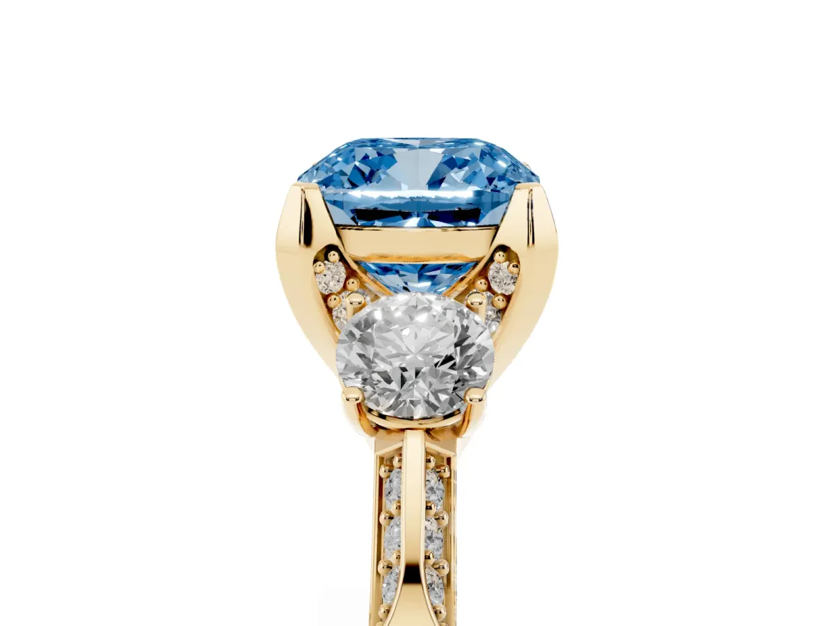 Fancy Blue Cushion Cut Brilliant Three-Stone Diamond Ring with Pavé Band and Four-Prong Setting Yellow gold