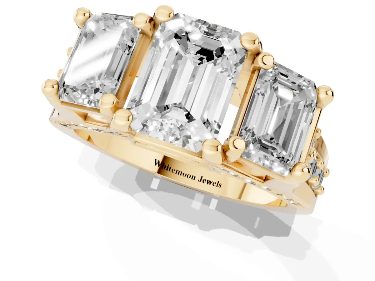 Emerald Cut Diamond Three-Stone Ring with Channel Set Band and Four-Prong Setting Yellow gold